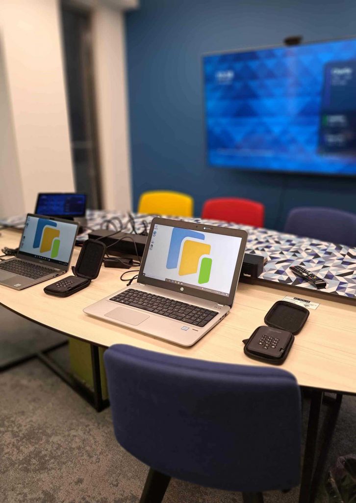 Sustainable Tech 4 Good onsite at client premises with ST4G logo showing on laptop screens on desks